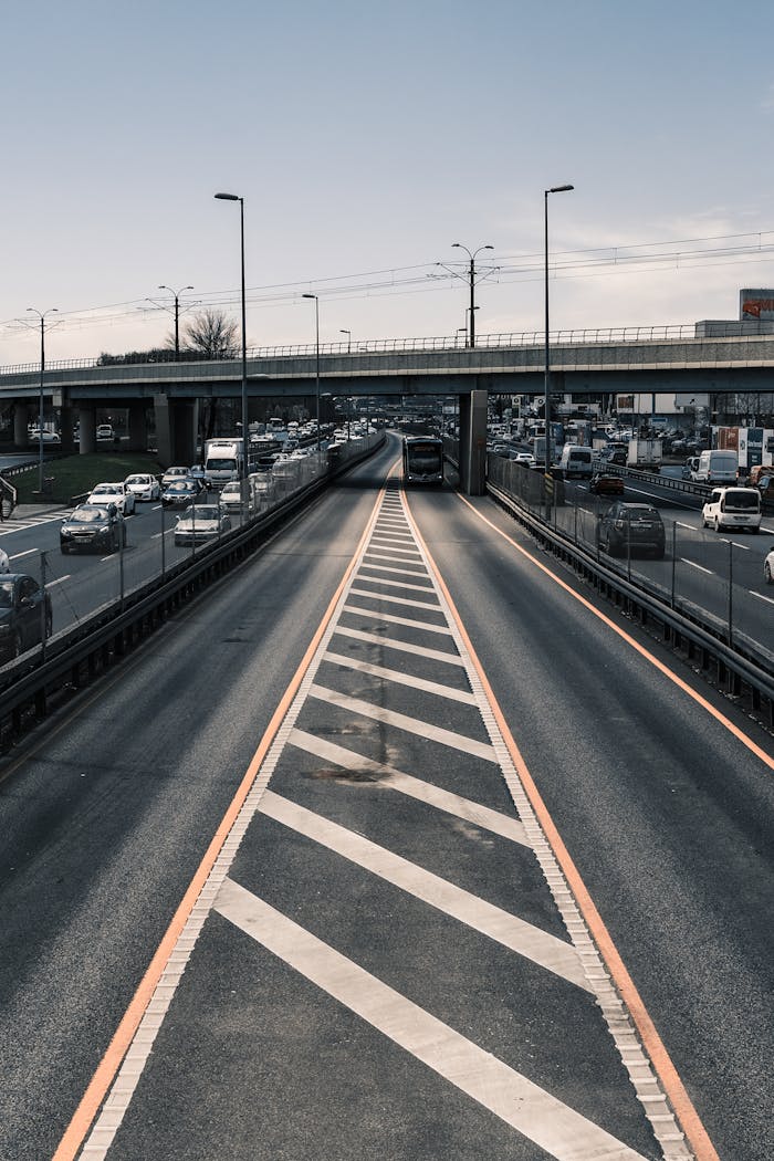 Aerial view of a busy urban highway showing cars, bridge, and traffic congestion.